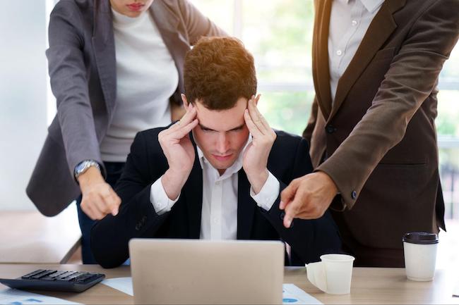 person getting stressed at work whilst being told off